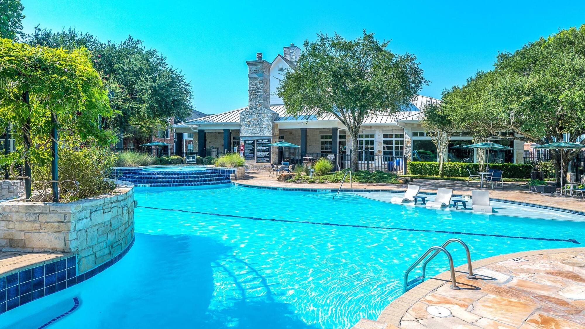 Coles Crossing resort-style swimming pool with spa and stone clubhouse in Cypress, Texas.