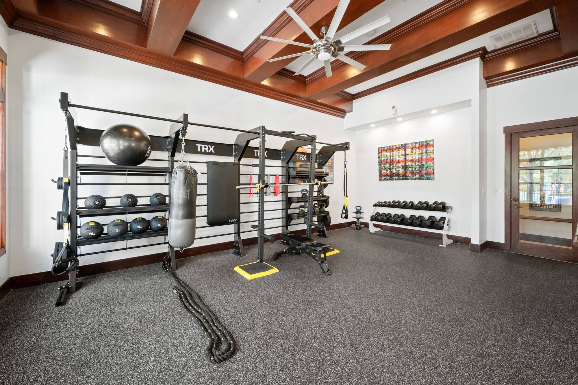 Coles Crossing fitness center with TRX station, free weights, punching bag, and battle ropes in Cypress, Texas.