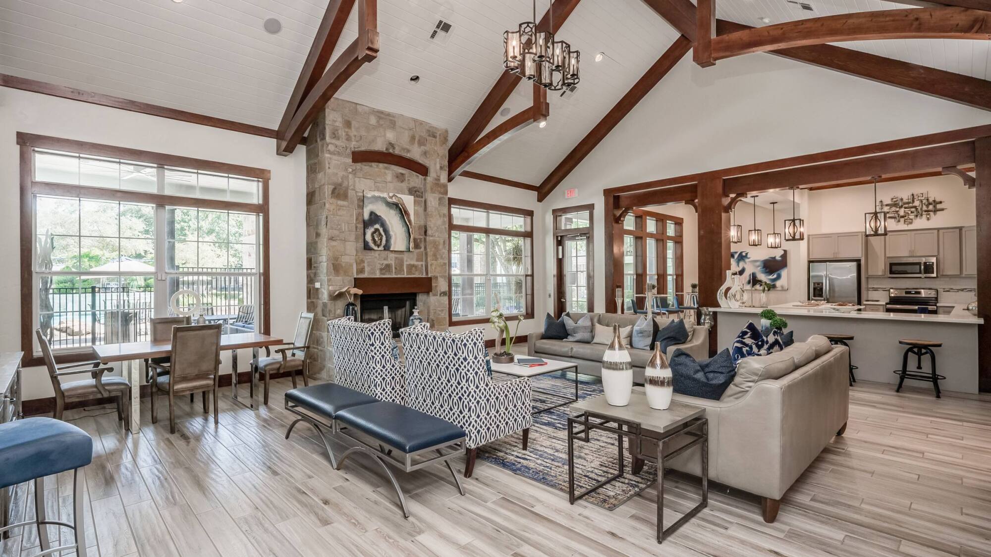 Coles Crossing clubhouse lounge with stone fireplace, vaulted wood-beam ceilings, and seating in Cypress, Texas.